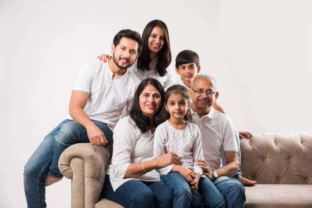 Indian/asian family sitting on sofa or couch over white background