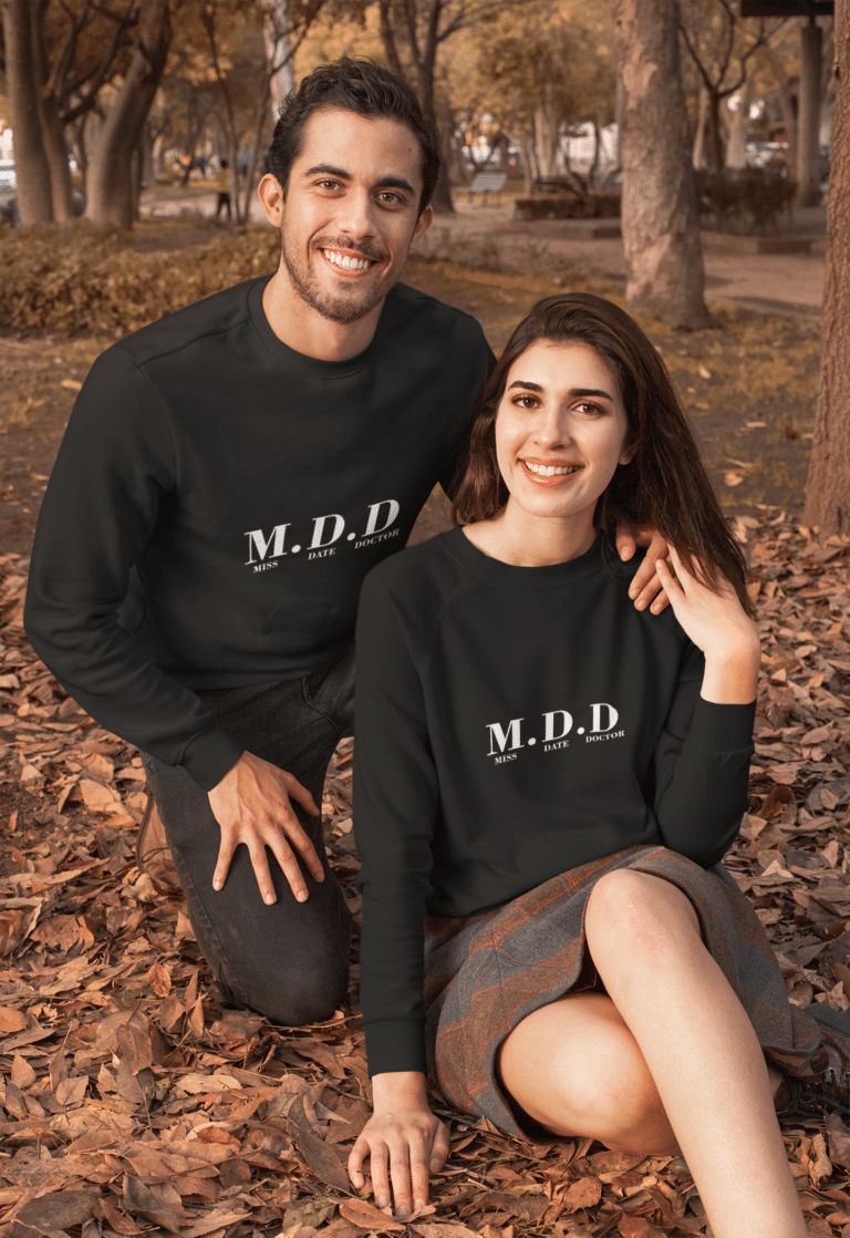 mockup of a couple wearing customizable crewneck sweatshirts at a park during autumn 31813