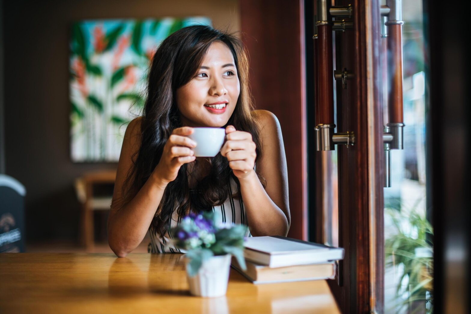 Post breakup social reintegration counselling — woman reconnecting with friends in café after breakup